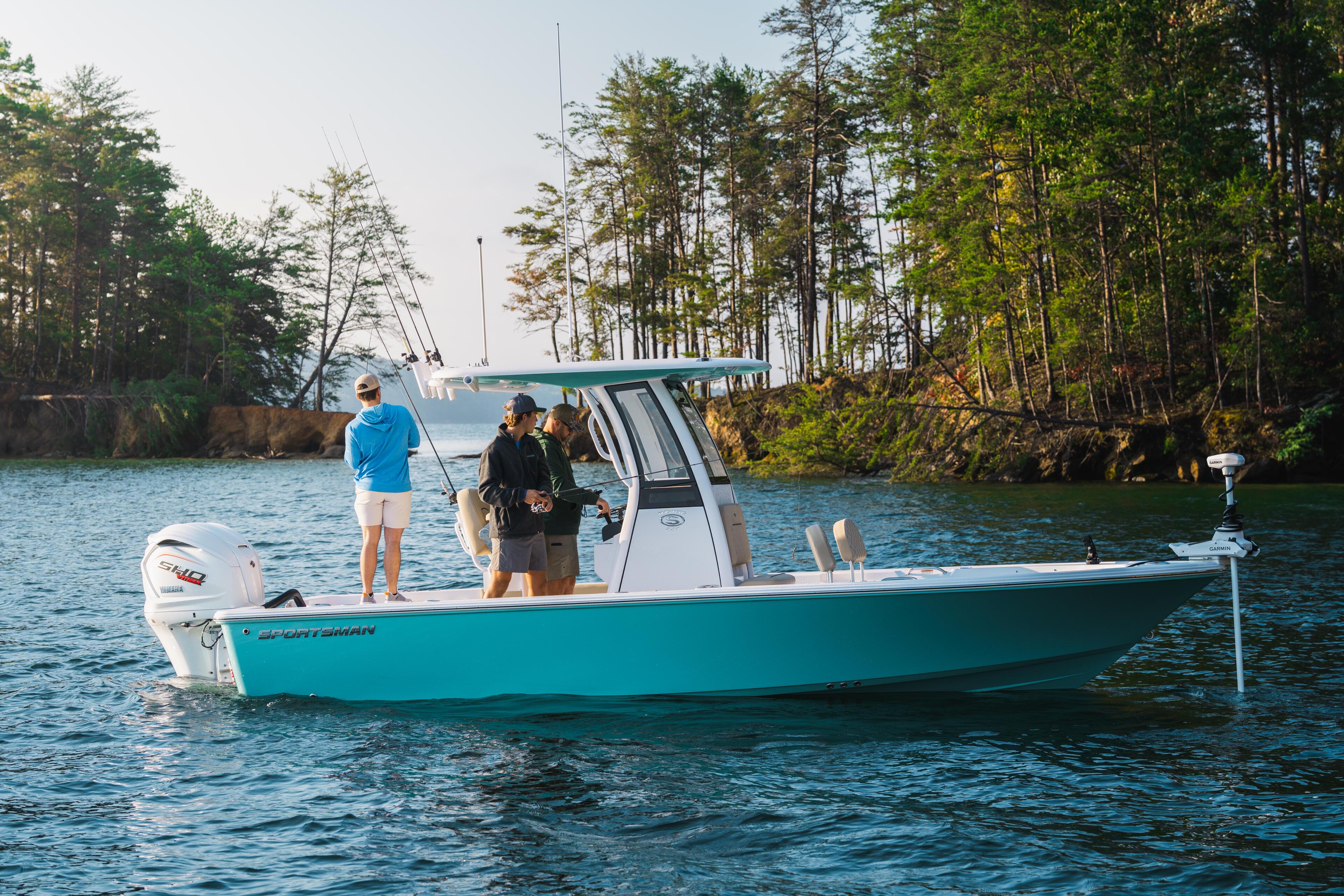 Turquoise fishing boat with anglers anchored in calm lake waters surrounded by pine trees