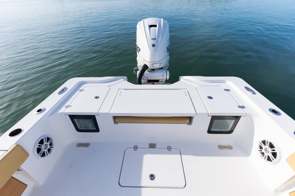 Stern view of a white center console boat with dual outboard engines and electronics displays