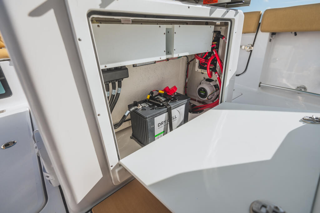 Open battery compartment with dual batteries, electrical wiring, and circuit protection systems mounted on interior wall