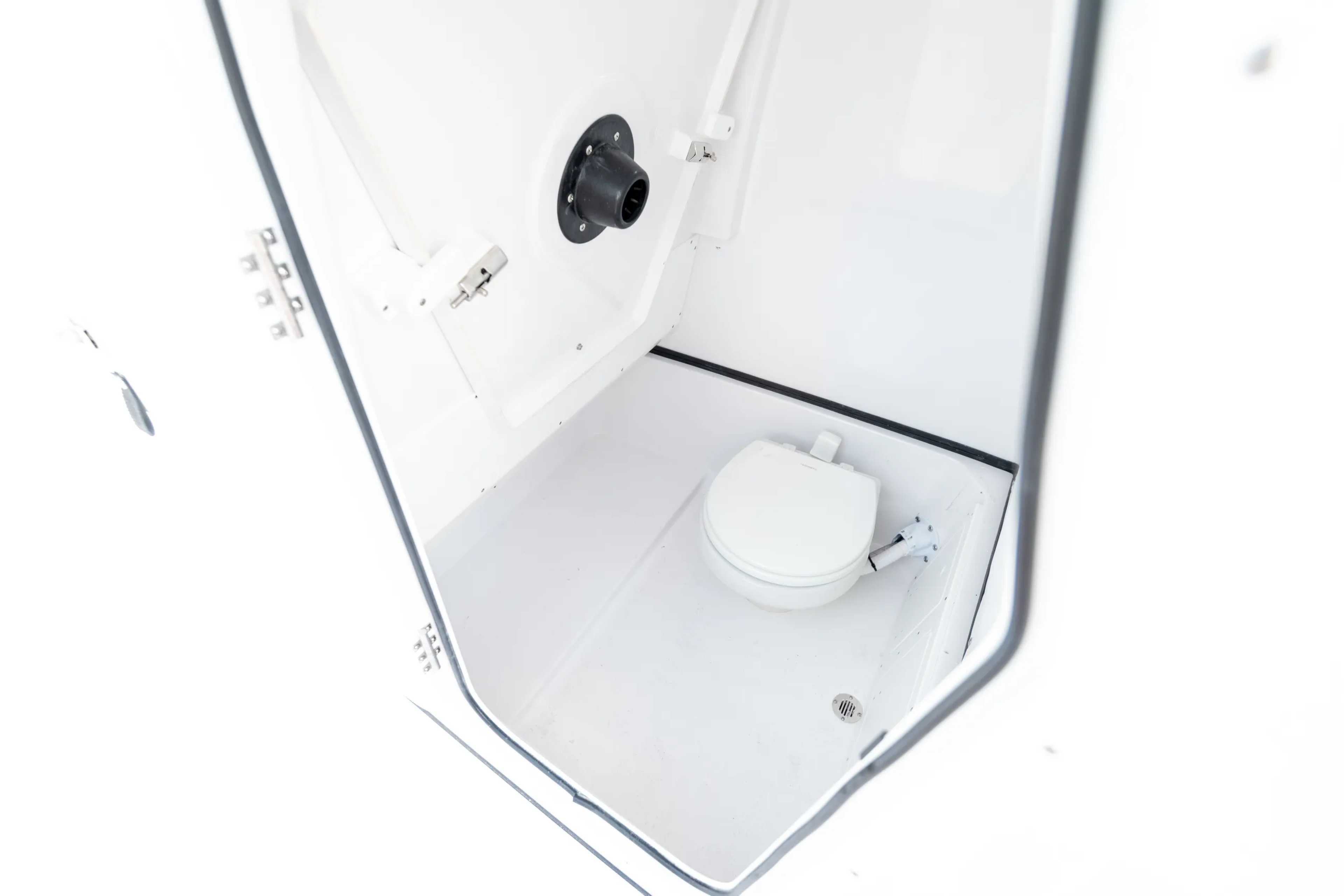 Overhead view of a boat cabin head with white porcelain toilet, vent, and electrical fixtures