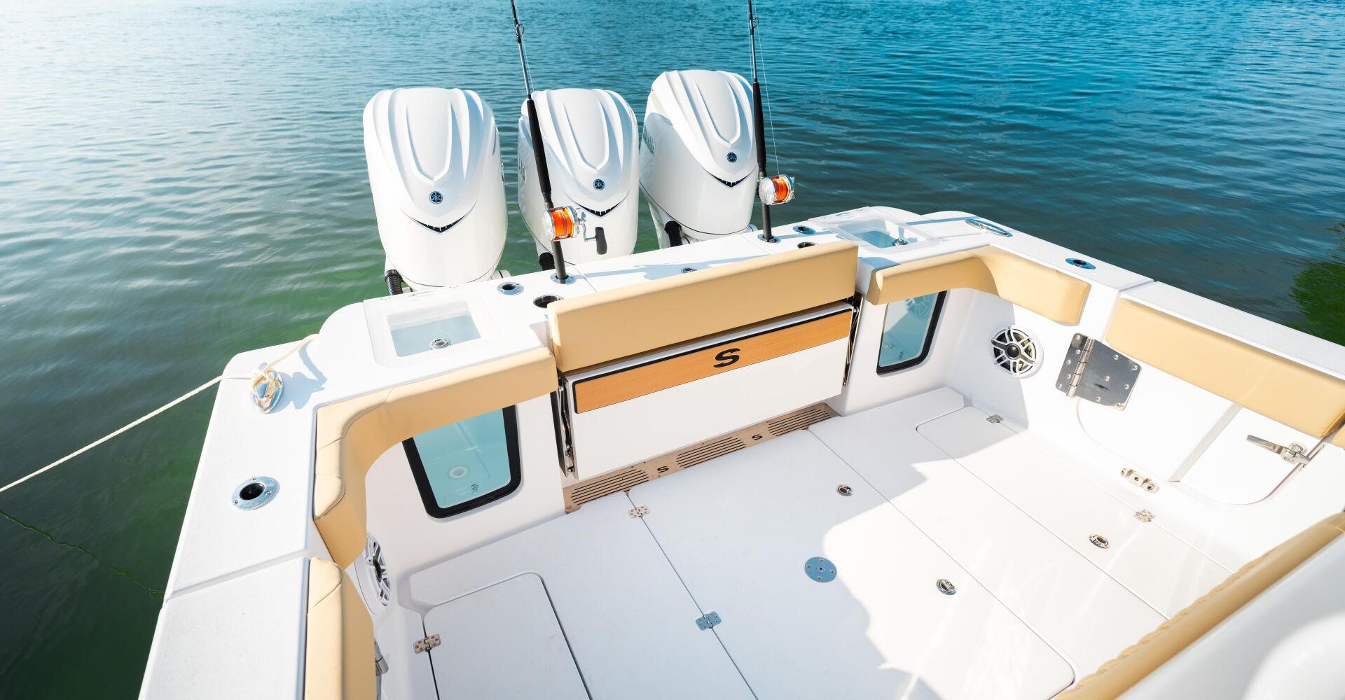 Triple outboard engines and spacious open cockpit with tan accents on center console fishing boat