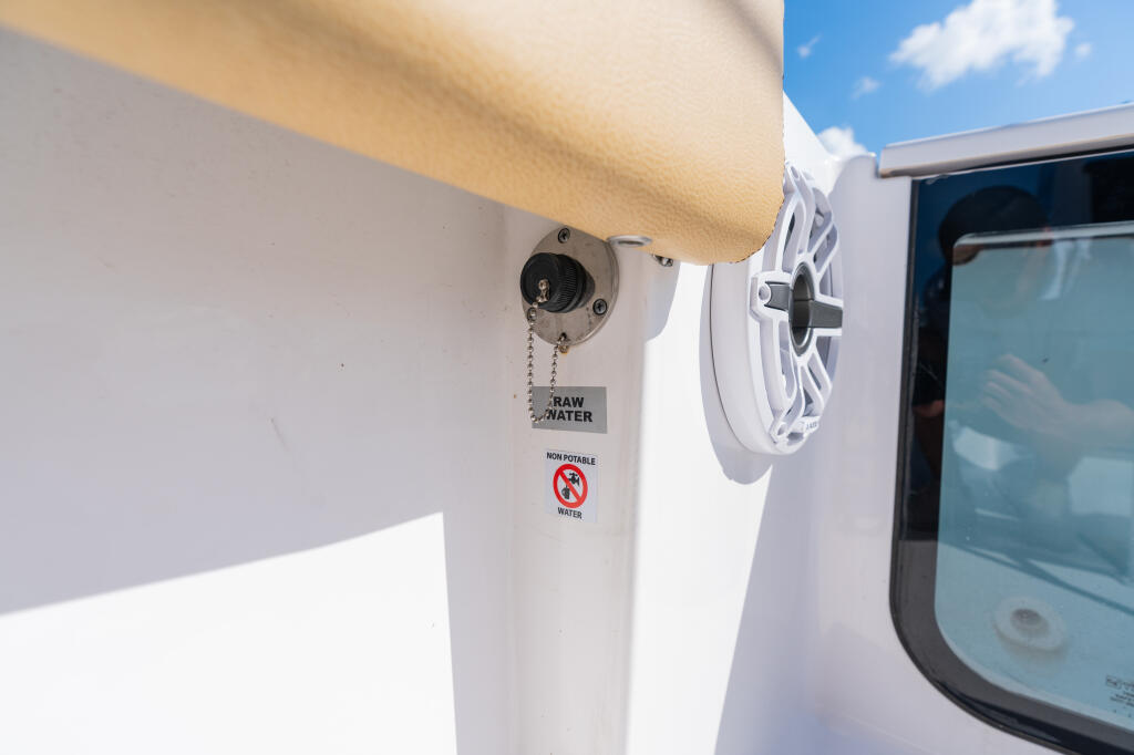 Raw water washdown valve mounted on the side of a boat with non-potable water warning label and speaker nearby