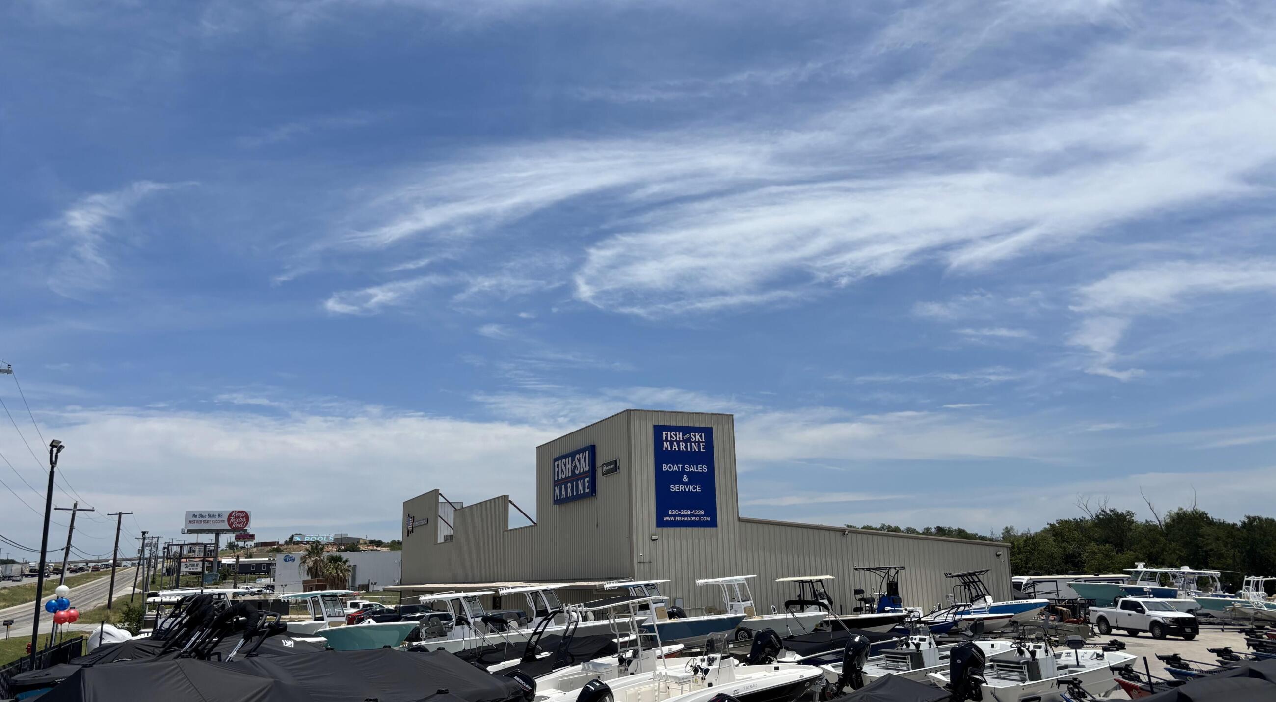 Fish and Ski Marine dealership with multiple boats docked and covered under a metal structure