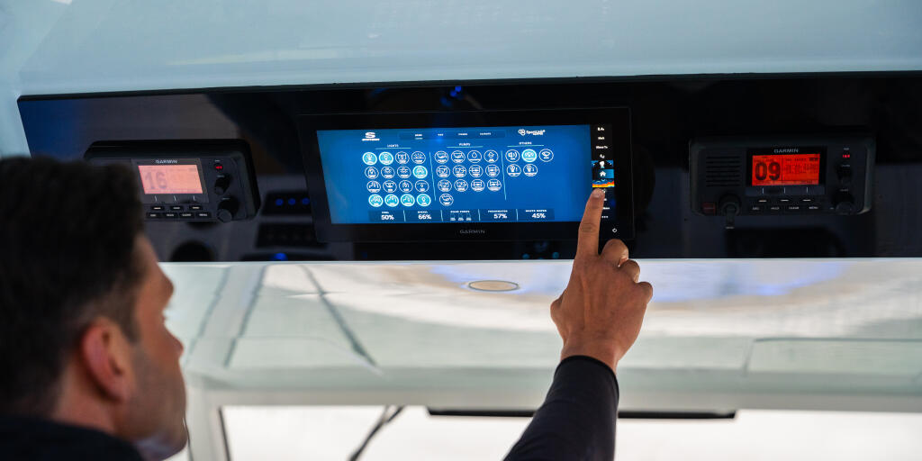 Operator interacting with touchscreen display and electronic instruments at boat helm