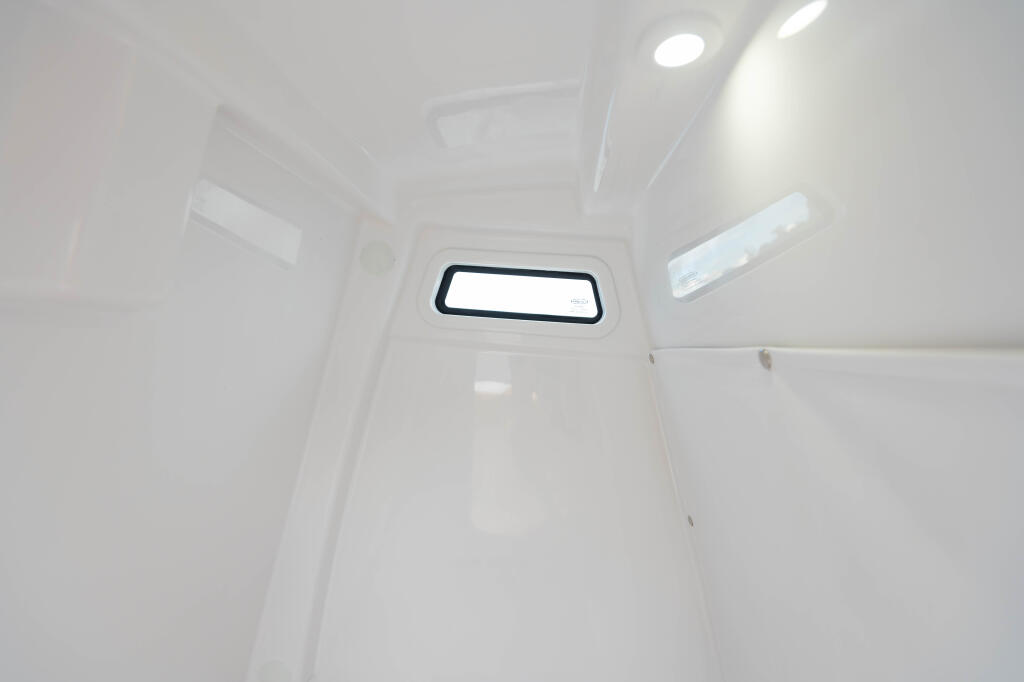 Bright cabin interior with recessed lighting and a large rectangular window with dark trim