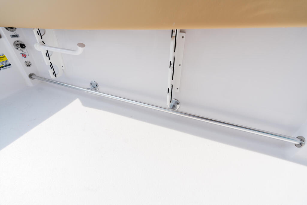 Overhead view of a boat's white cabin with ventilation ports and stainless steel railing along the side