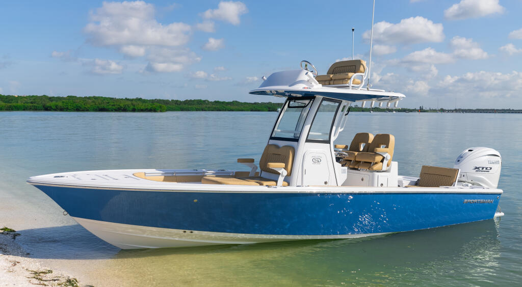 Blue and white center console boat beached in shallow turquoise water with mangrove shoreline