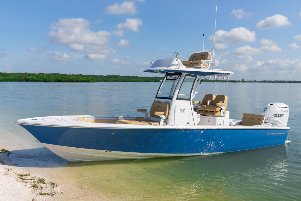 Blue and white center console boat beached in shallow turquoise water with mangrove shoreline