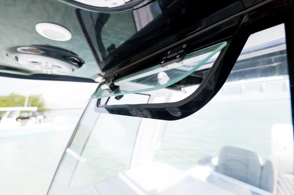 Cabin interior showing integrated tempered glass windshield with manual vent window and recessed lighting