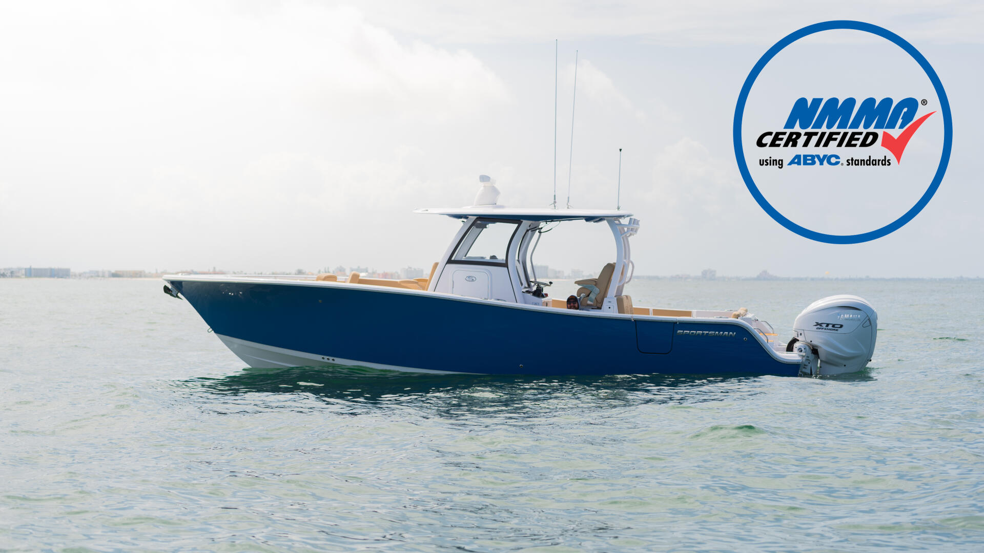 Blue and white center console fishing boat anchored in shallow water with outboard engine