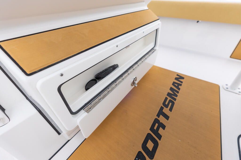 Helm pod storage compartment with tan cushioning, white interior, and cable management access