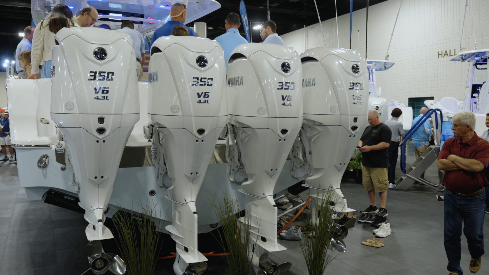 Row of white marine outboard engines with 350 V6 4.3L markings displayed at a boat show