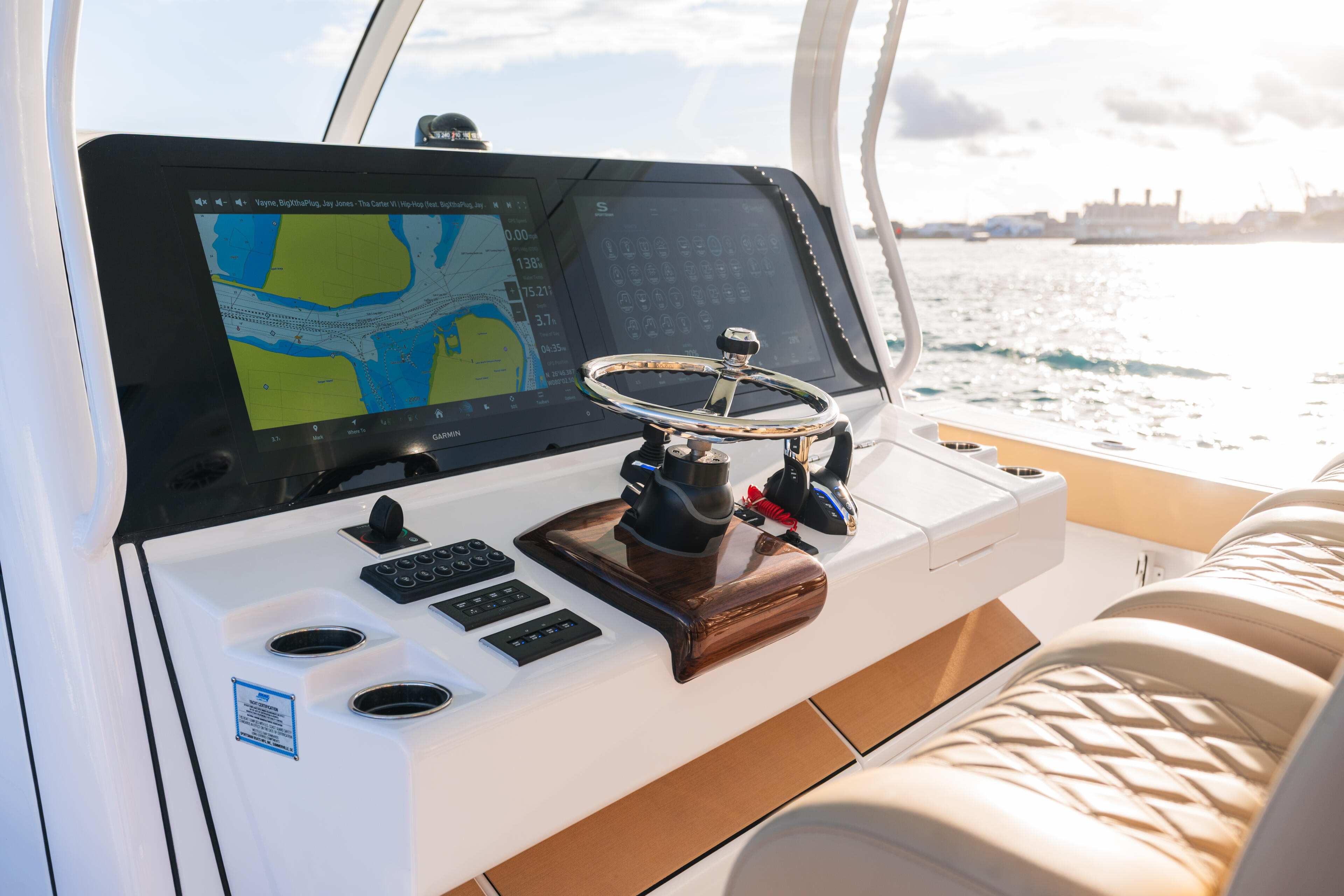 Helm station with GPS chartplotter display, wheel, and control panels overlooking open water