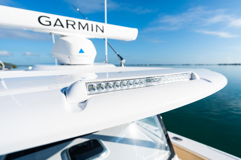 Garmin radar and Razor LED lighting system mounted on boat hardtop with calm marina waters in background
