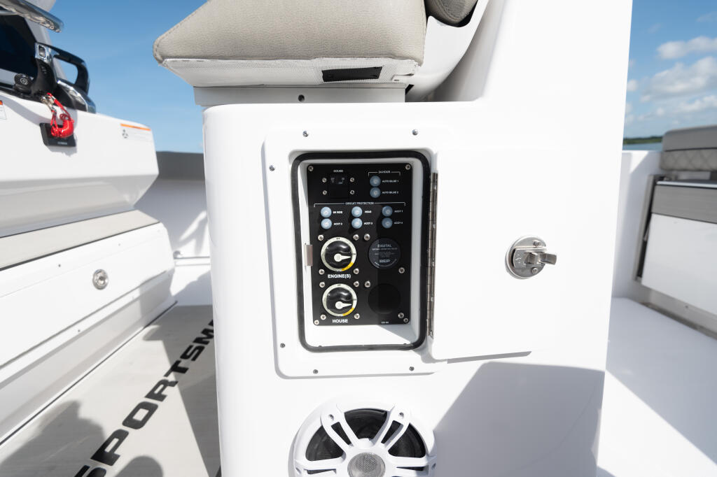 Engine and house battery switch panel mounted on white console with analog gauges and control buttons
