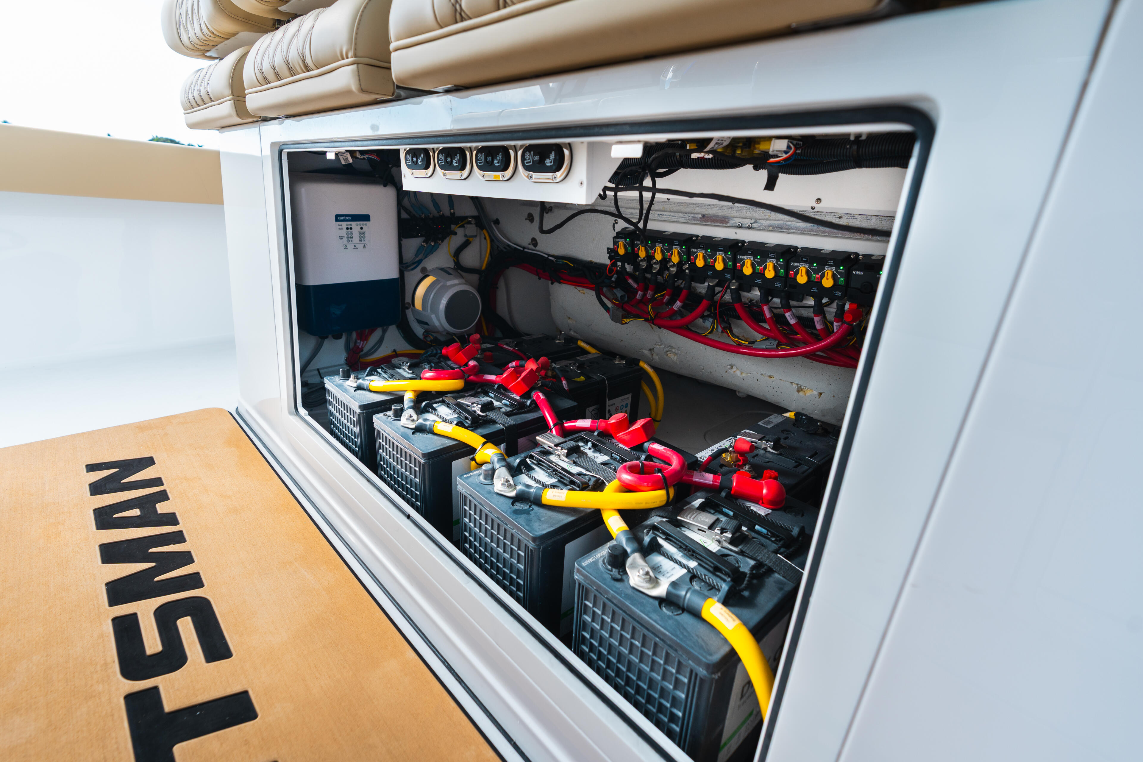 Open engine compartment displaying organized battery banks, electrical panels, and color-coded wiring systems