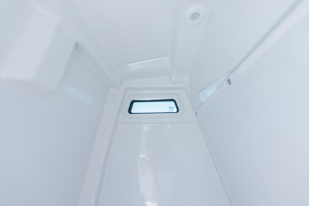 Bright cabin interior with horizontal window featuring dark frame and translucent curtain rod above