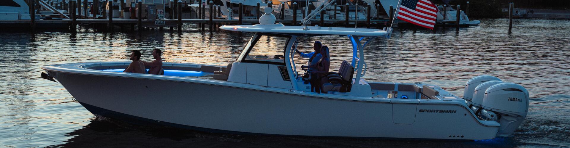 Blue and white sportsman boat anchored at sunset with couple aboard near Sailfish Marina in Stuart, Florida