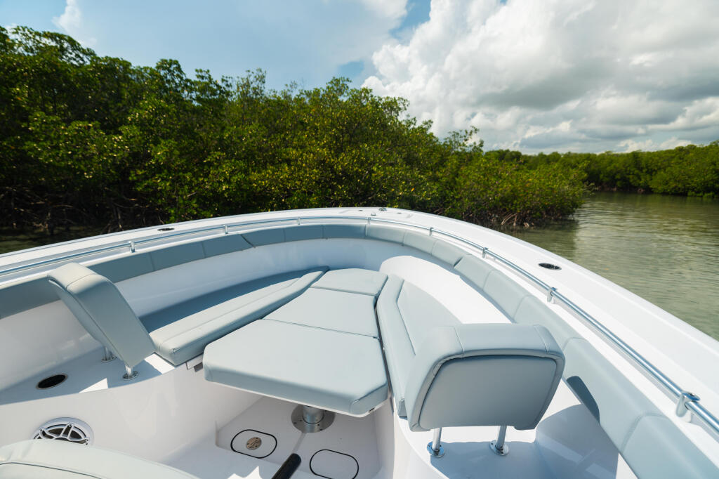 Spacious bow seating and console in a white center console boat surrounded by mangrove shoreline