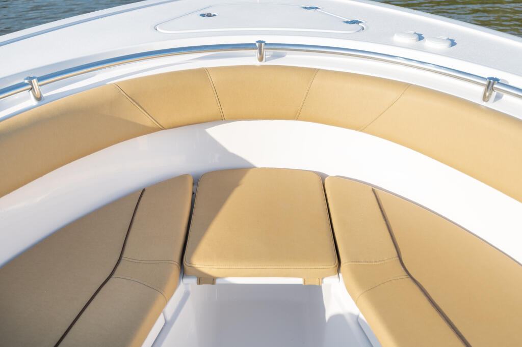 Tan and white cushioned seating with removable filler board in center console boat
