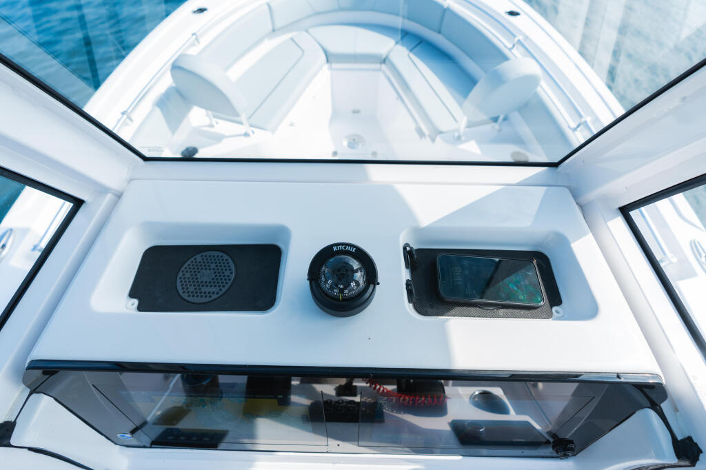 Center console hardtop with compass, speaker, and electronics display mounted on white overhead panel