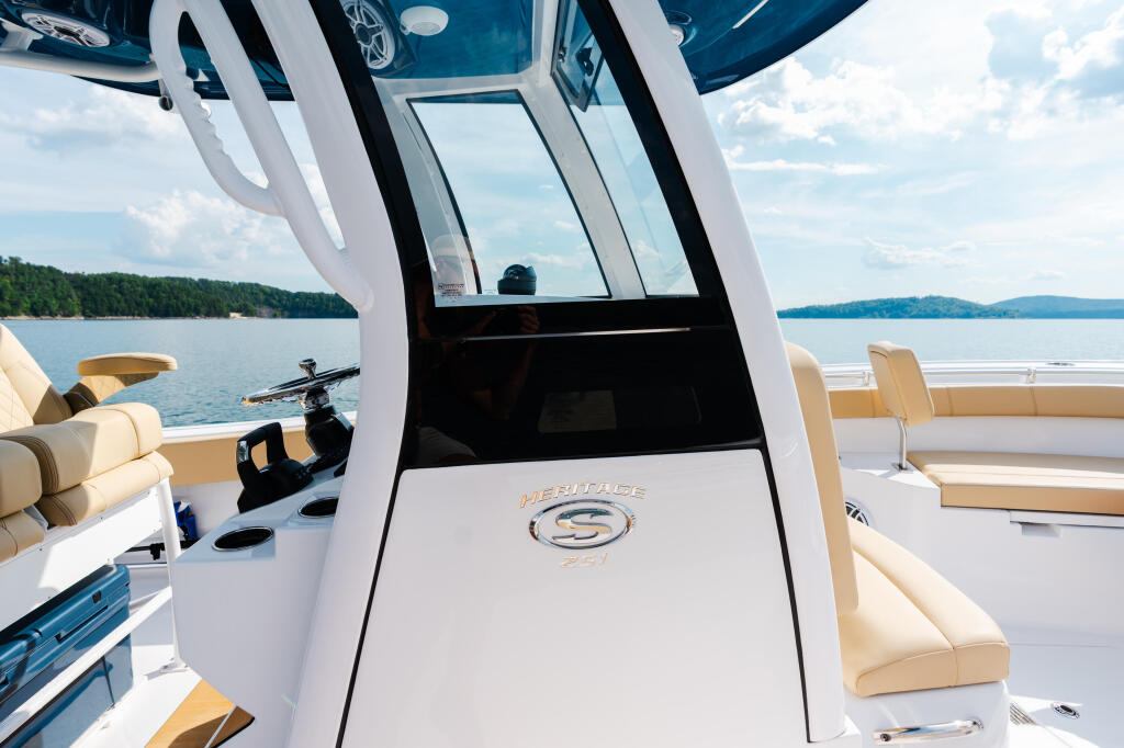 Hard-top boat cabin with open door, cream seating, and lake view from the helm area