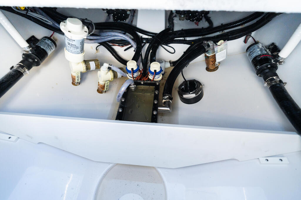 Engine compartment showing plumbing, filters, and electrical components integrated into boat systems