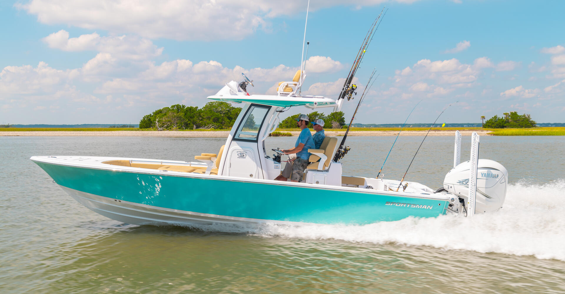 Turquoise bay boat with fishing rods running through shallow coastal waters near mangroves