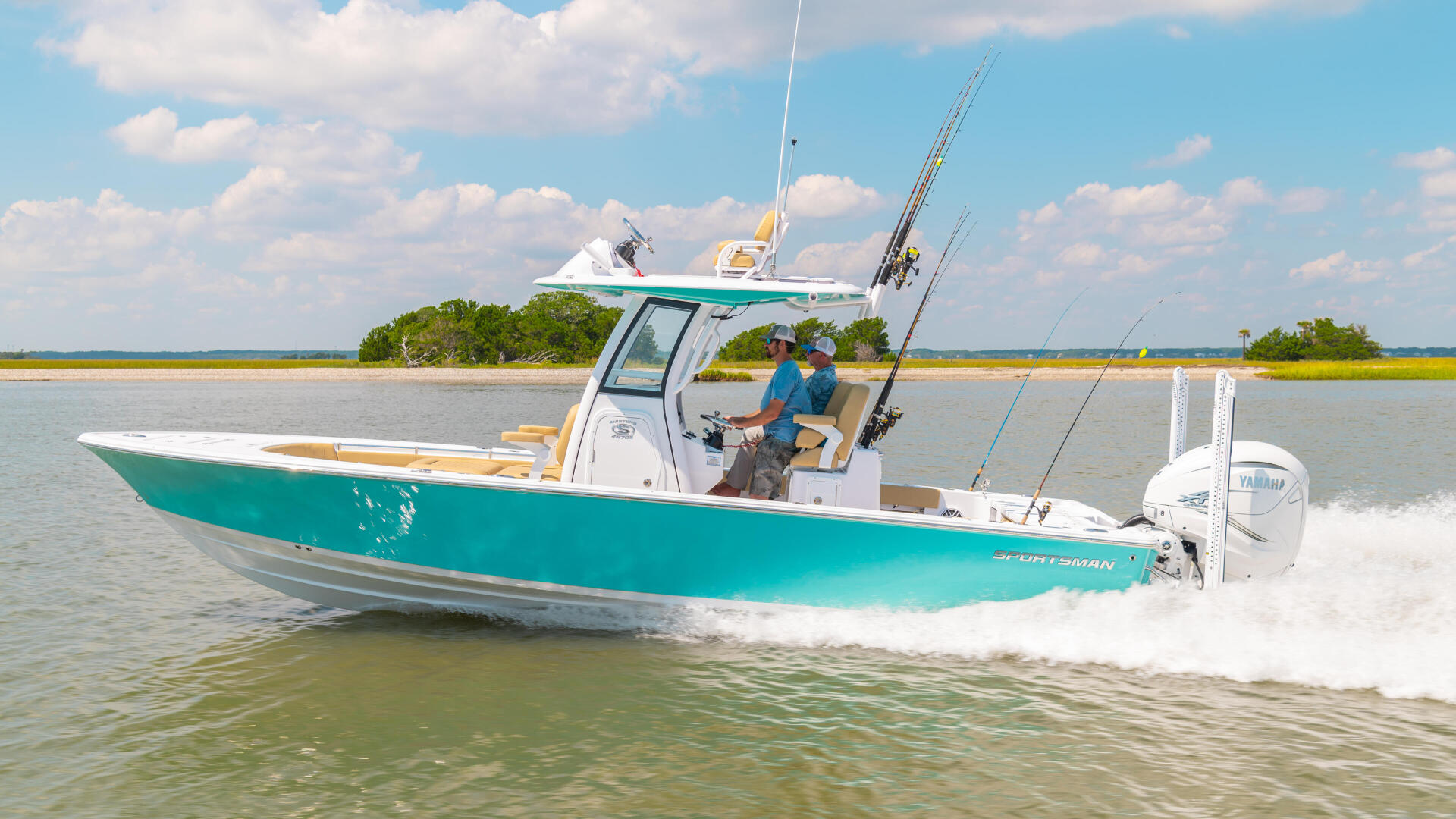 Turquoise bay boat with fishing rods running through shallow coastal waters near mangroves