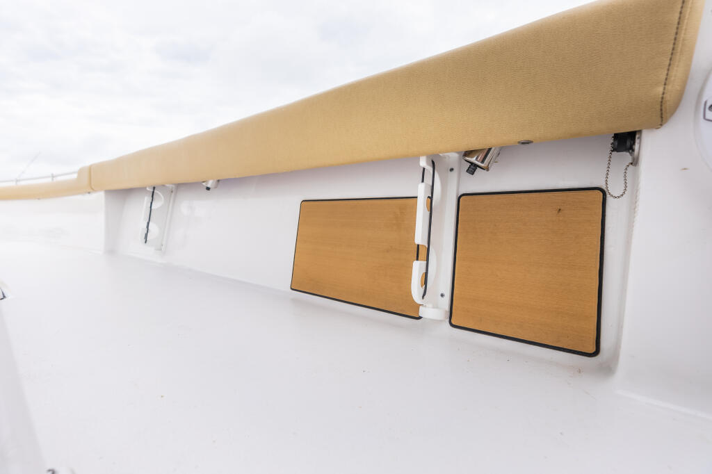 Tan retractable awning with wooden folding rod racks mounted on boat cabin wall