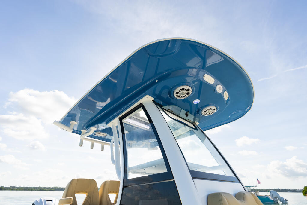 Blue hard-top with integrated tempered glass windshield and manual vent on a center console boat