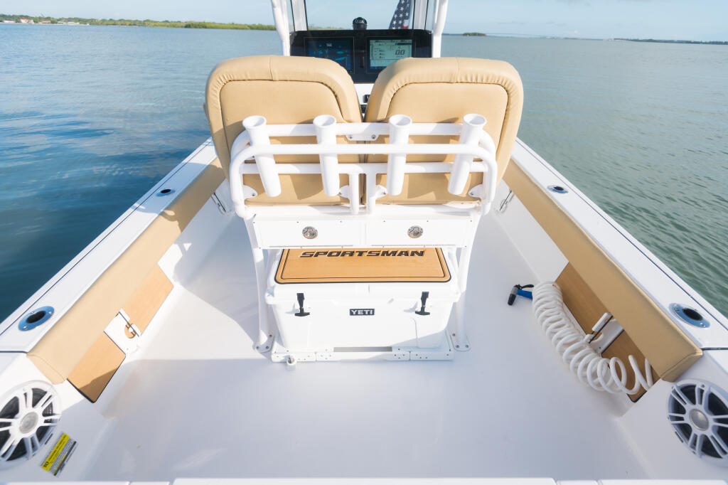 Sportsman center console boat with tan cushioned seating, white railing, and helm electronics visible from above on calm water