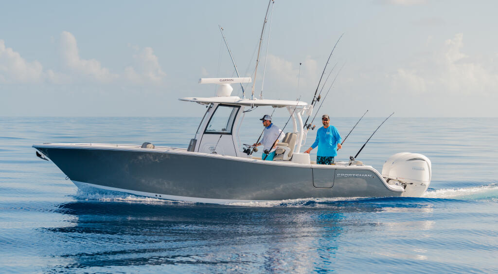 Two anglers fishing from a center console boat in calm offshore waters with multiple fishing rods deployed