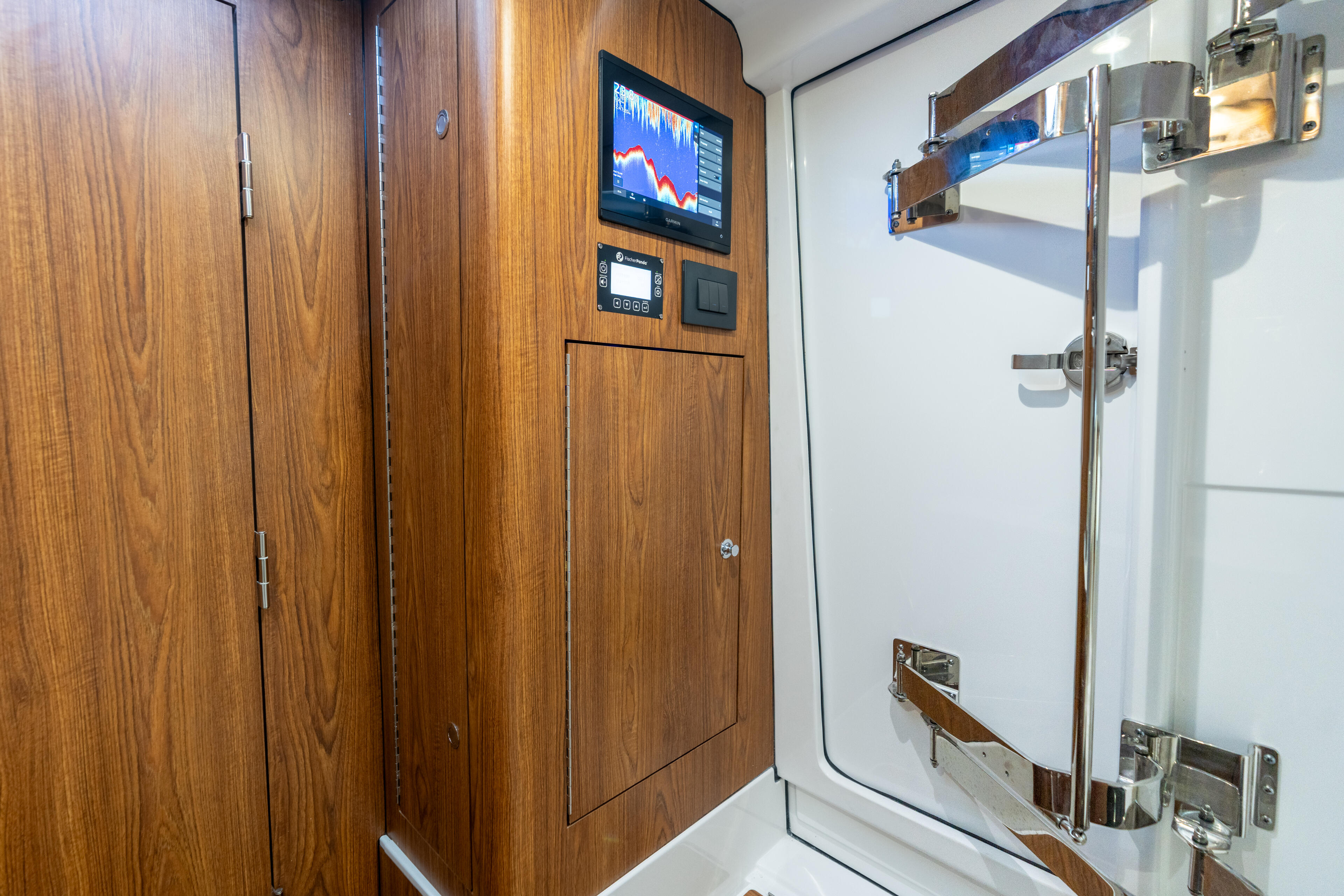 Boat cabin interior with wood cabinetry, electronics display, and navigation systems