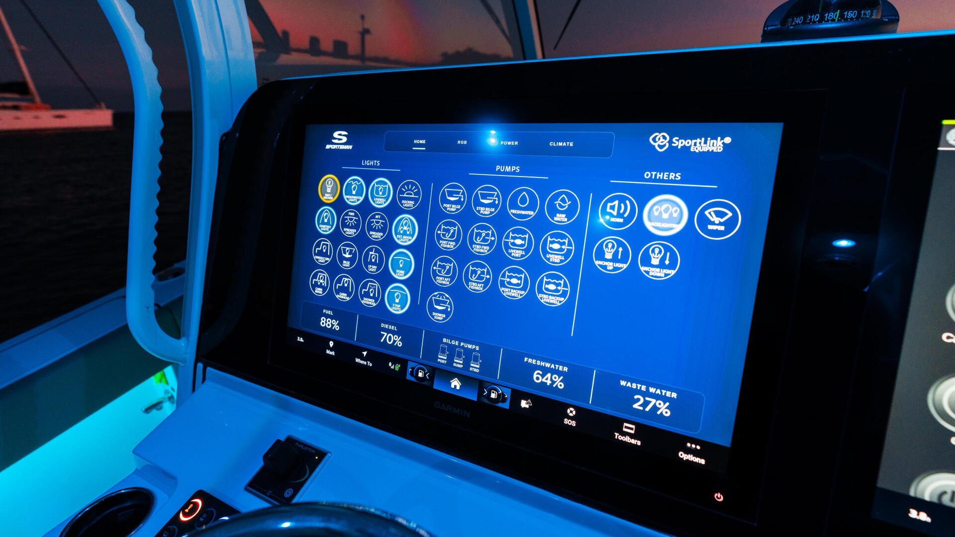 SportLink touchscreen display showing vessel systems monitoring with illuminated control panel at the helm during sunset