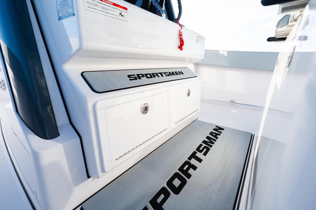 Sportsman boat deck with white cabin storage and branded non-slip flooring
