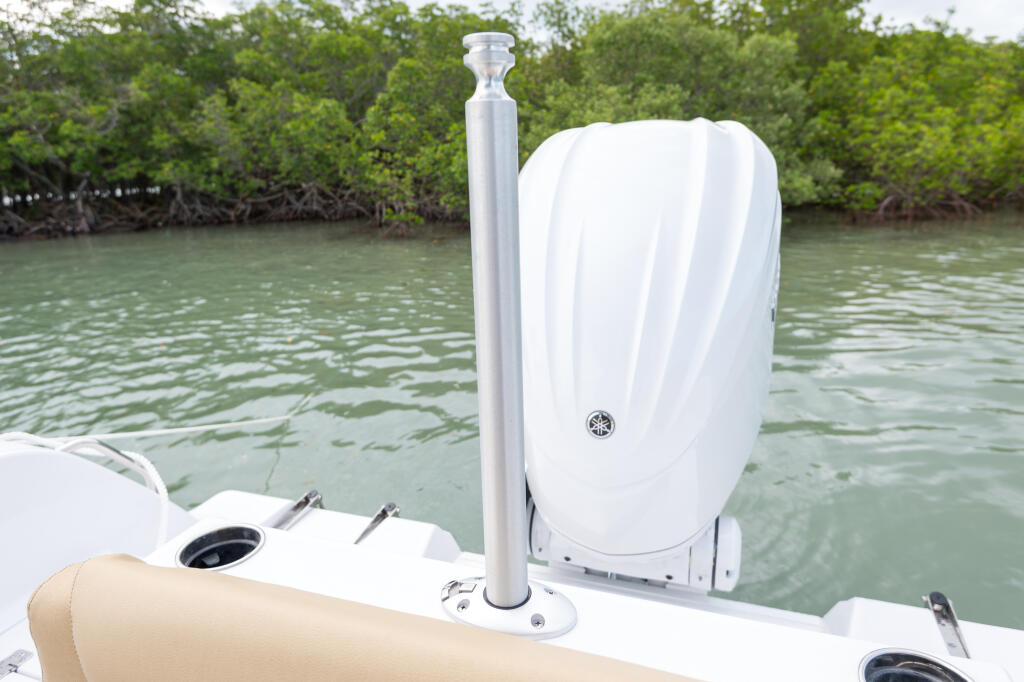 White telescoping ski tow bar mounted on boat console with mangrove shoreline in background