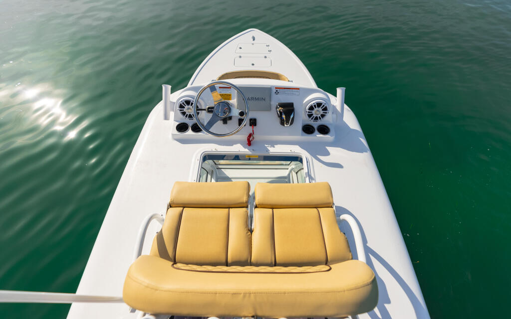 Overhead view of boat helm and yellow seating area with electronics and steering wheel visible