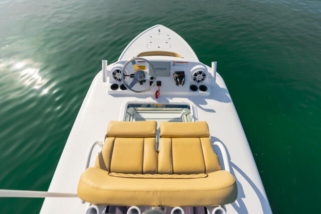 Overhead view of boat helm and yellow seating area with electronics and steering wheel visible