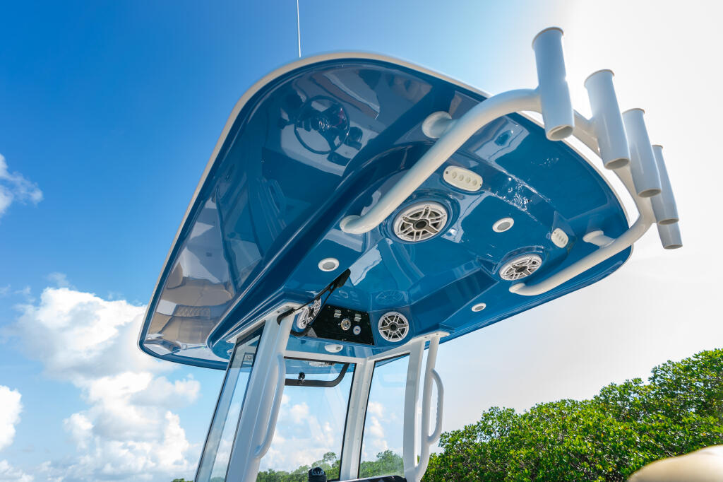 Overhead view of center console boat helm with dual engines, electronics, and white hard-top against blue sky