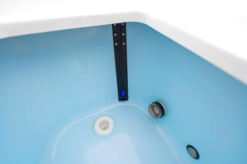 Boat livewell interior showing drain valve, aerator fitting, and blue LED light indicator