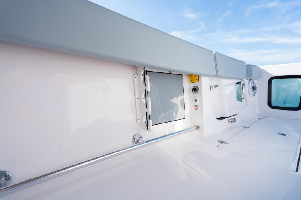 Boat's hardtop with electronics, window, and cabin entry under clear blue sky