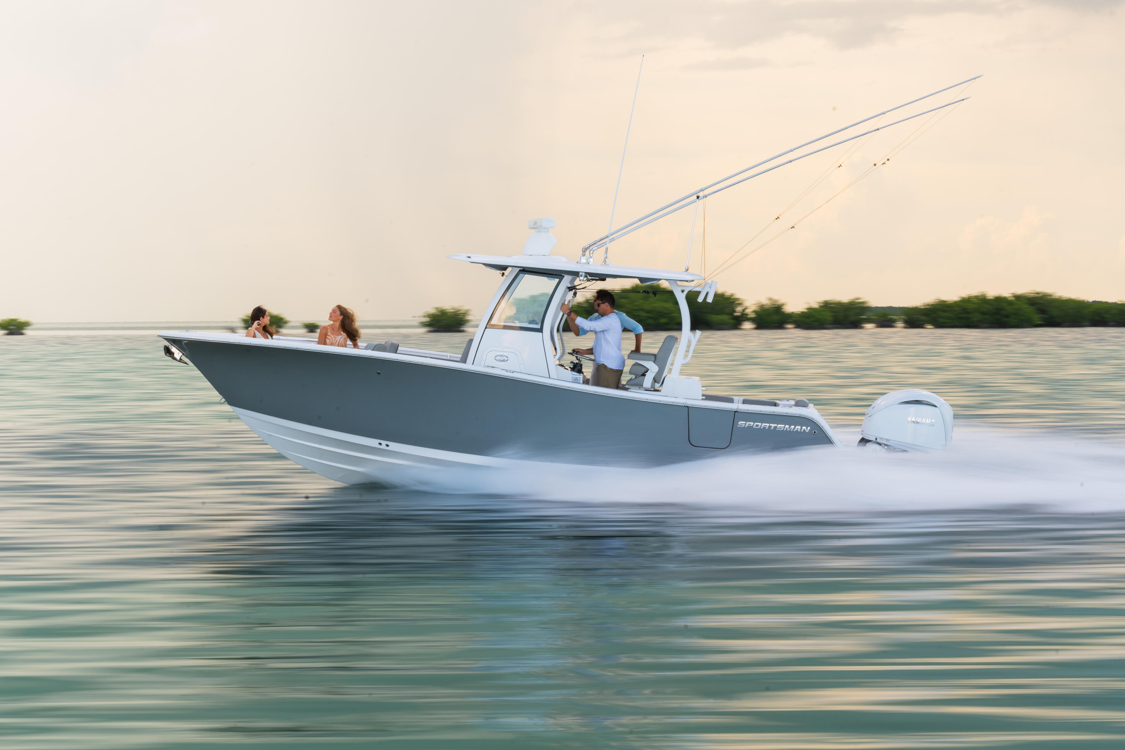 Sportsman center console boat running at speed with passengers enjoying a cruise on calm shallow waters near mangroves