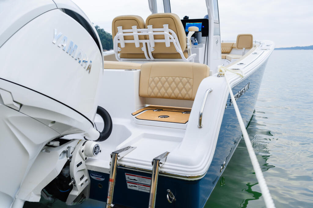 Tan and white center console boat with outboard engine at the dock on calm water