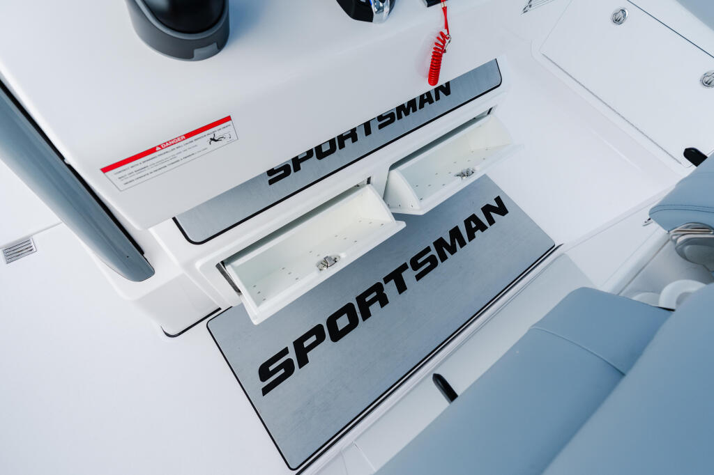 Sportsman boat helm console with white cushioned seating and red lanyard coiled on overhead mounting point