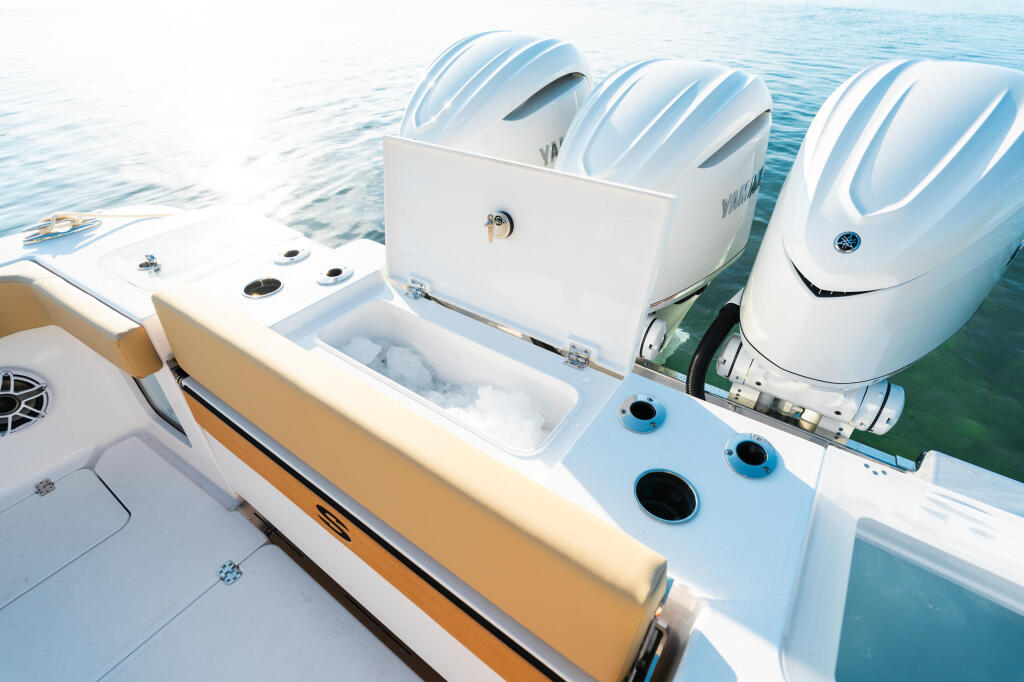 Multiple outboard engines mounted on boat transom with livewell and storage compartments visible