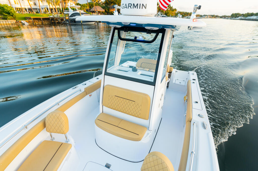 White and tan center console boat with Garmin electronics docked at a waterfront marina