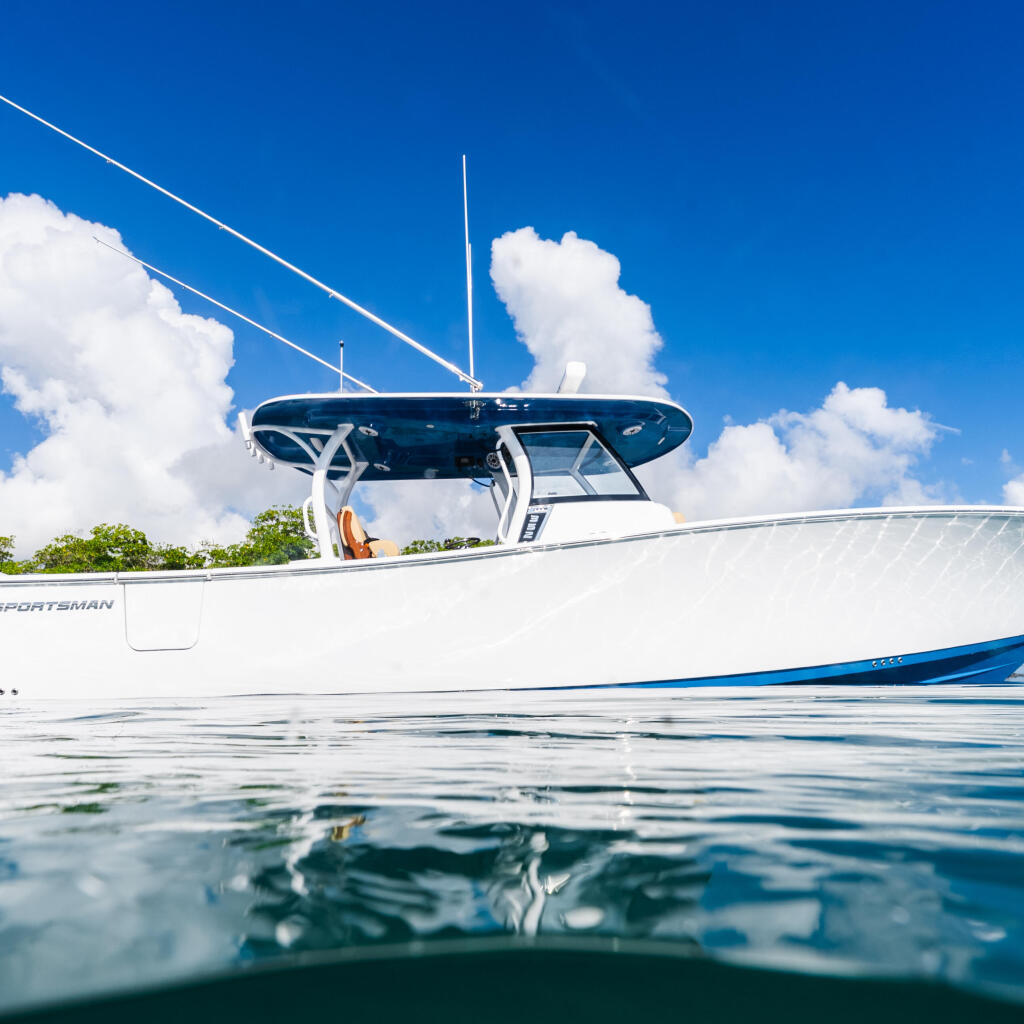 White Yamaha Sportsman boat with hard-top and twin engines anchored in clear blue water