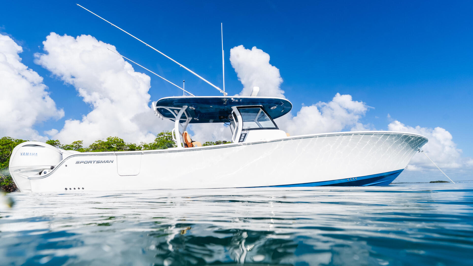 White Yamaha Sportsman boat with hard-top and twin engines anchored in clear blue water