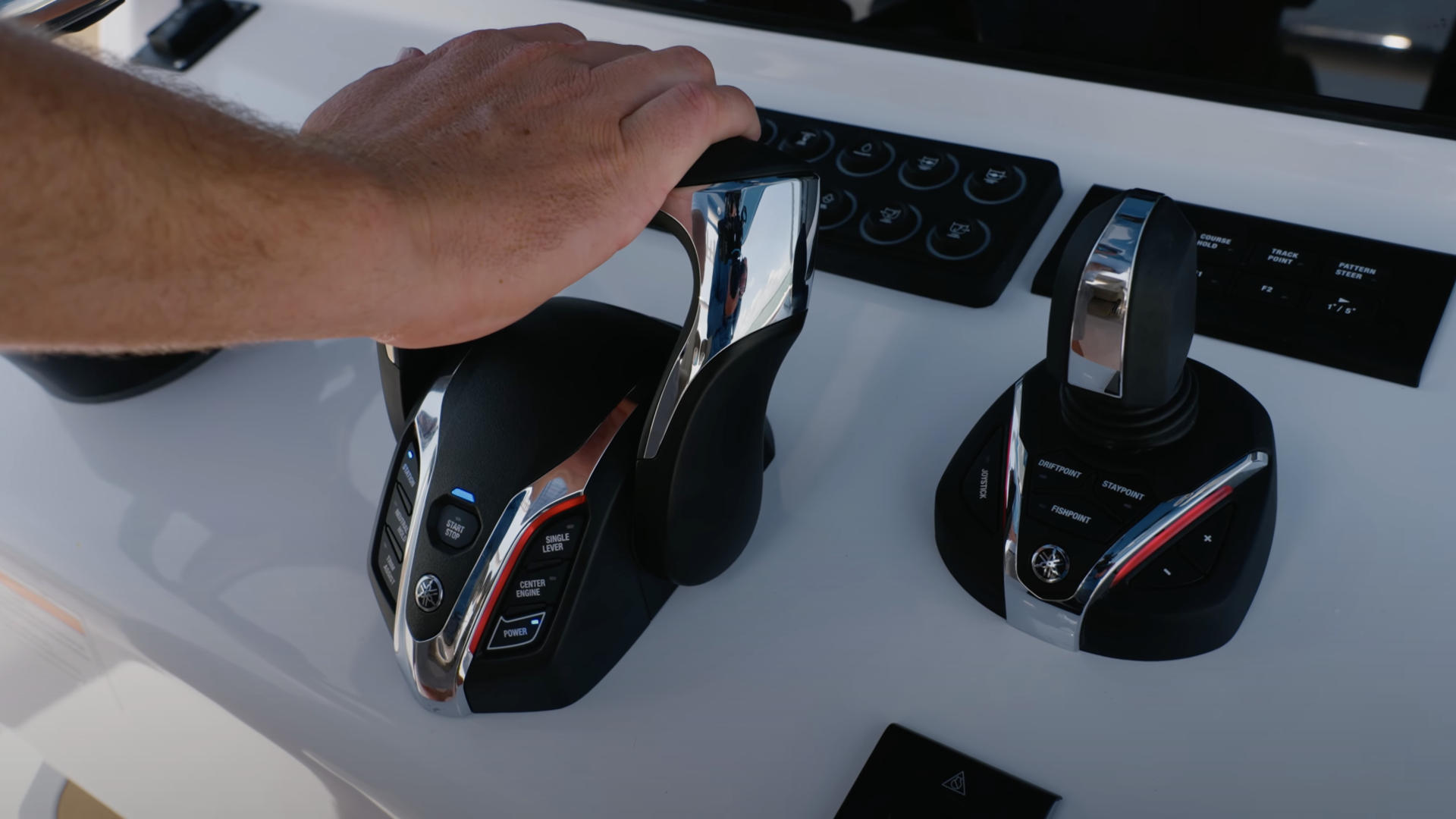 Hand operating dual throttle and shift controls at the boat's helm